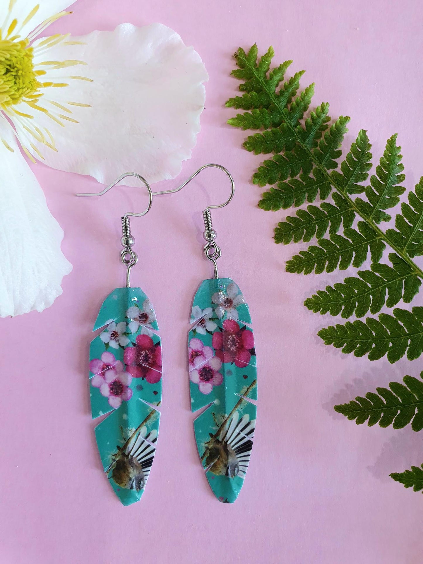 washi tape earrings in the shape of a feather with fantail and manuka flower design
