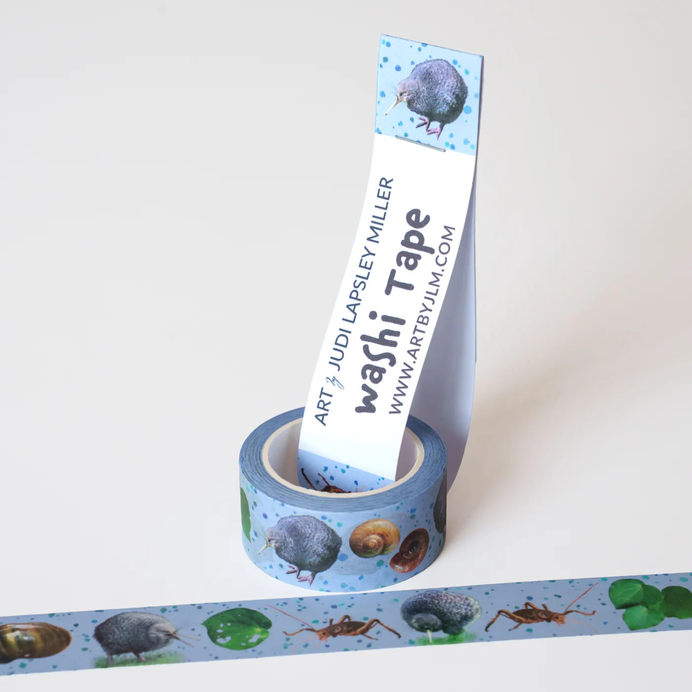 Roll of washi tape with kiwi illustrations on a silvery blue background