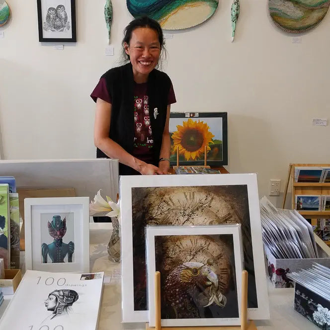 A smiling Sandra stands behind some of my fine-art prints