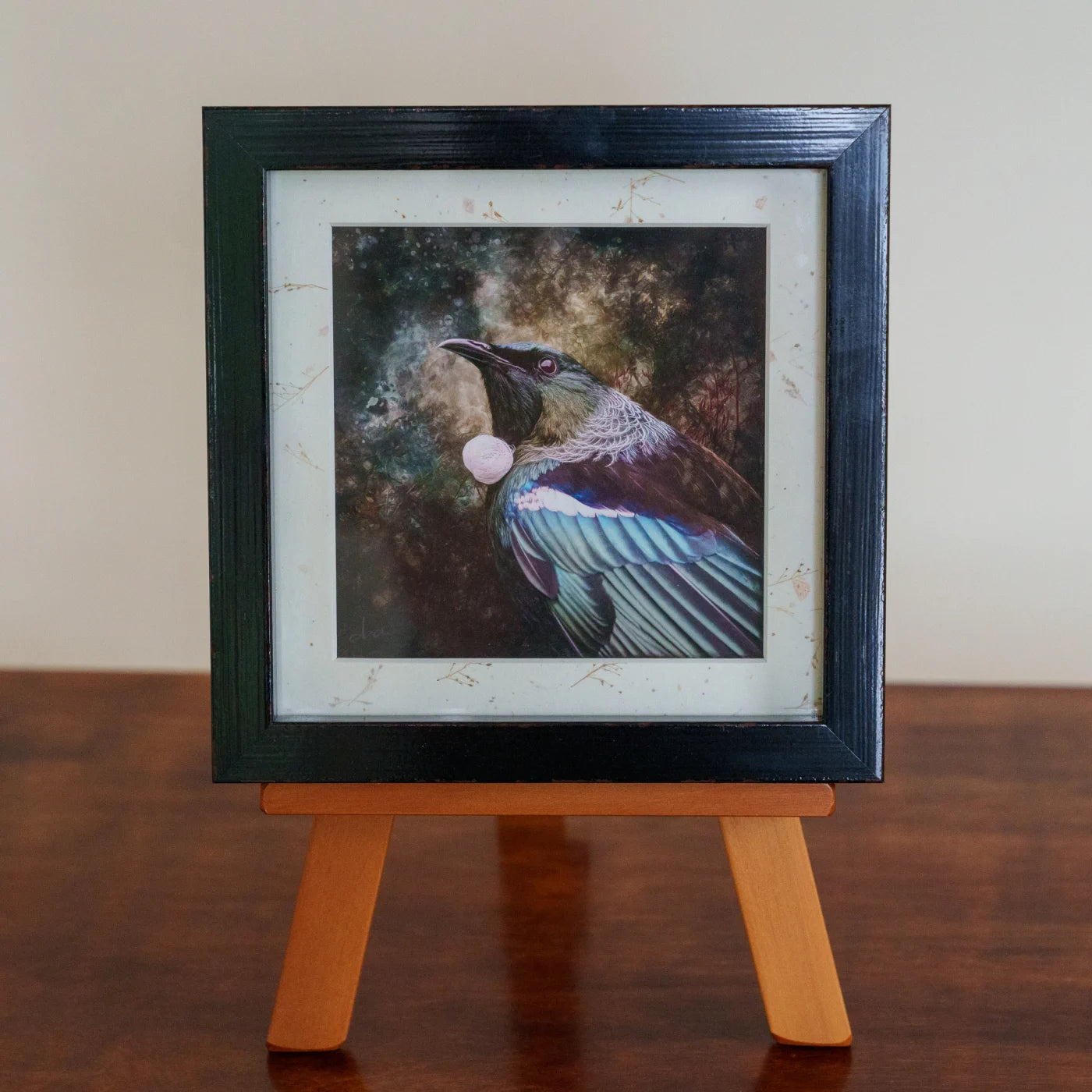 Framed artwork of a bird on a small easel against a plain background