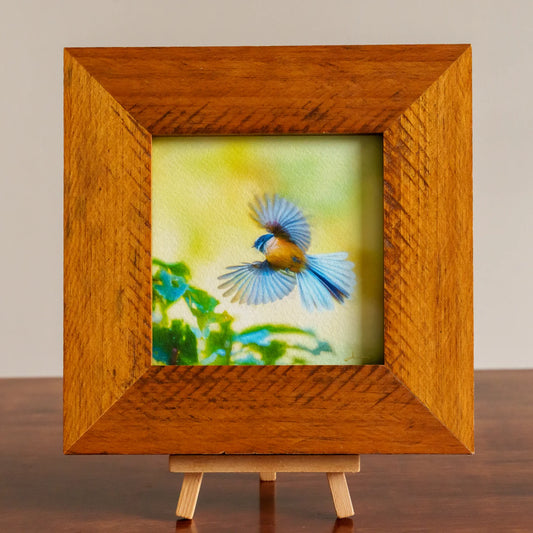 Wooden frame with a colorful bird painting on a stand