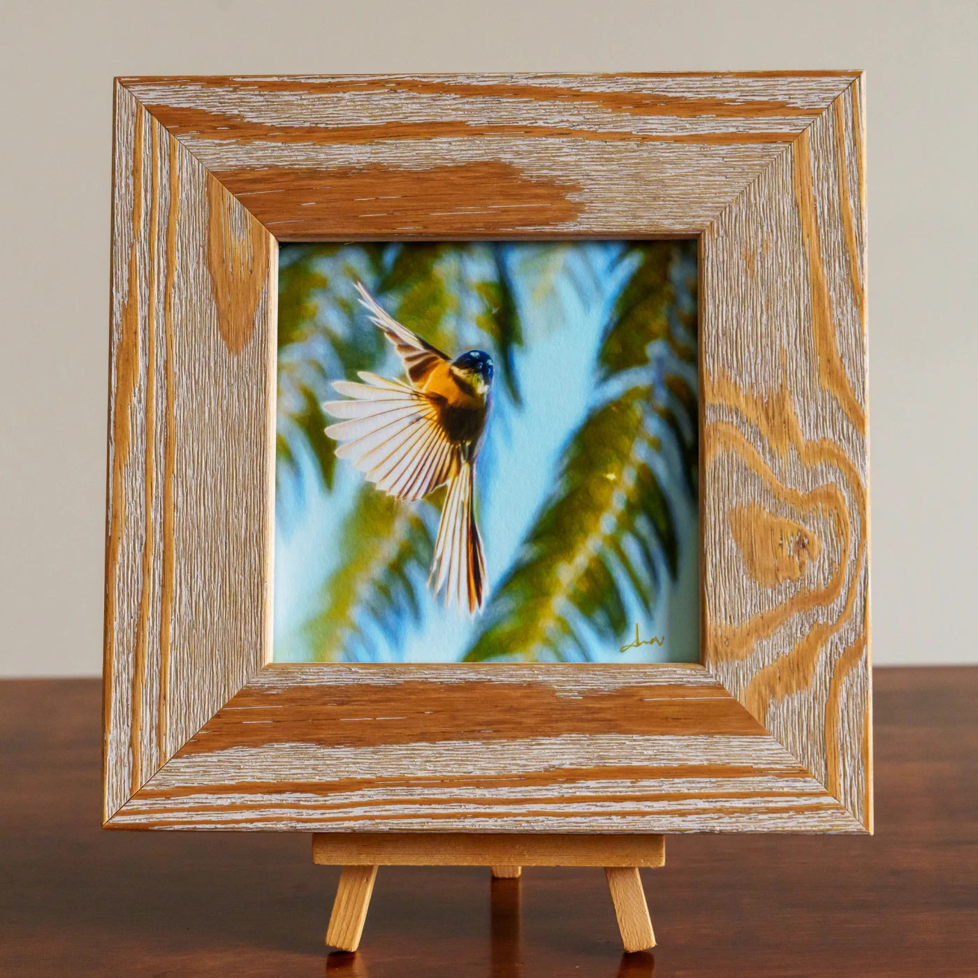 Wooden framed picture of a bird on a stand with a neutral background