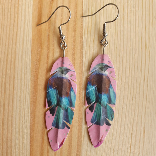 Tui earrings on wooden background