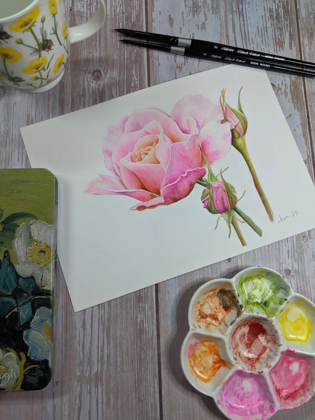 watercolour painting of a rose with art supplies