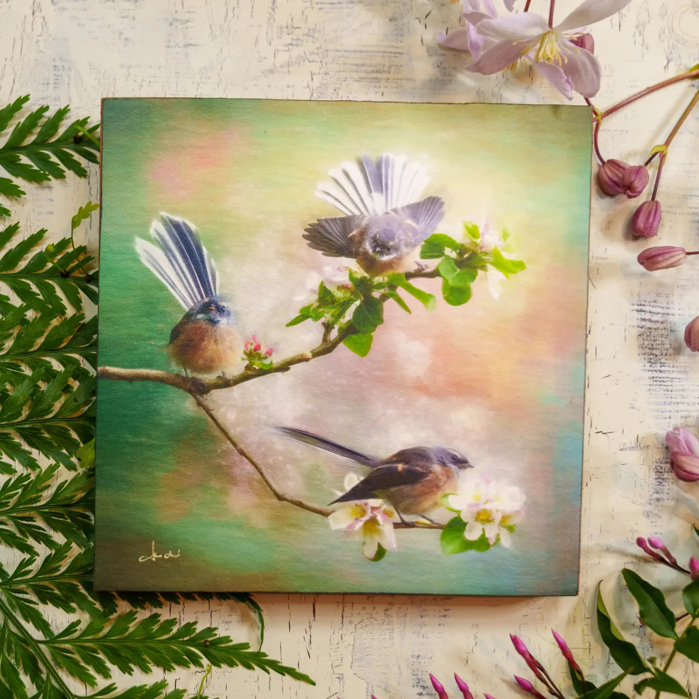 Artwork of three birds on a branch