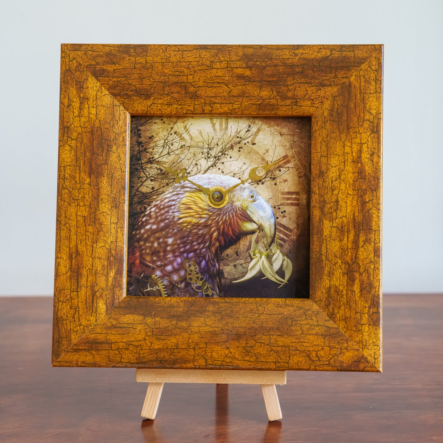 Wooden framed artwork of a bird with a textured background on a wooden stand.