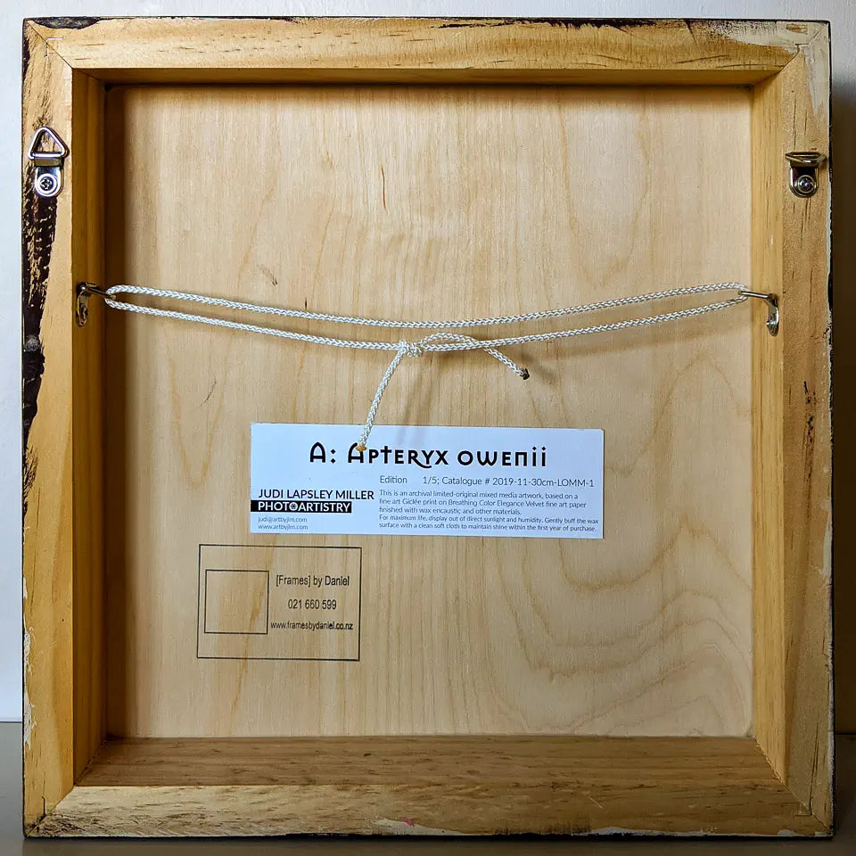 Back view of the artwork showing the wooden cradleboard and hanging hardware