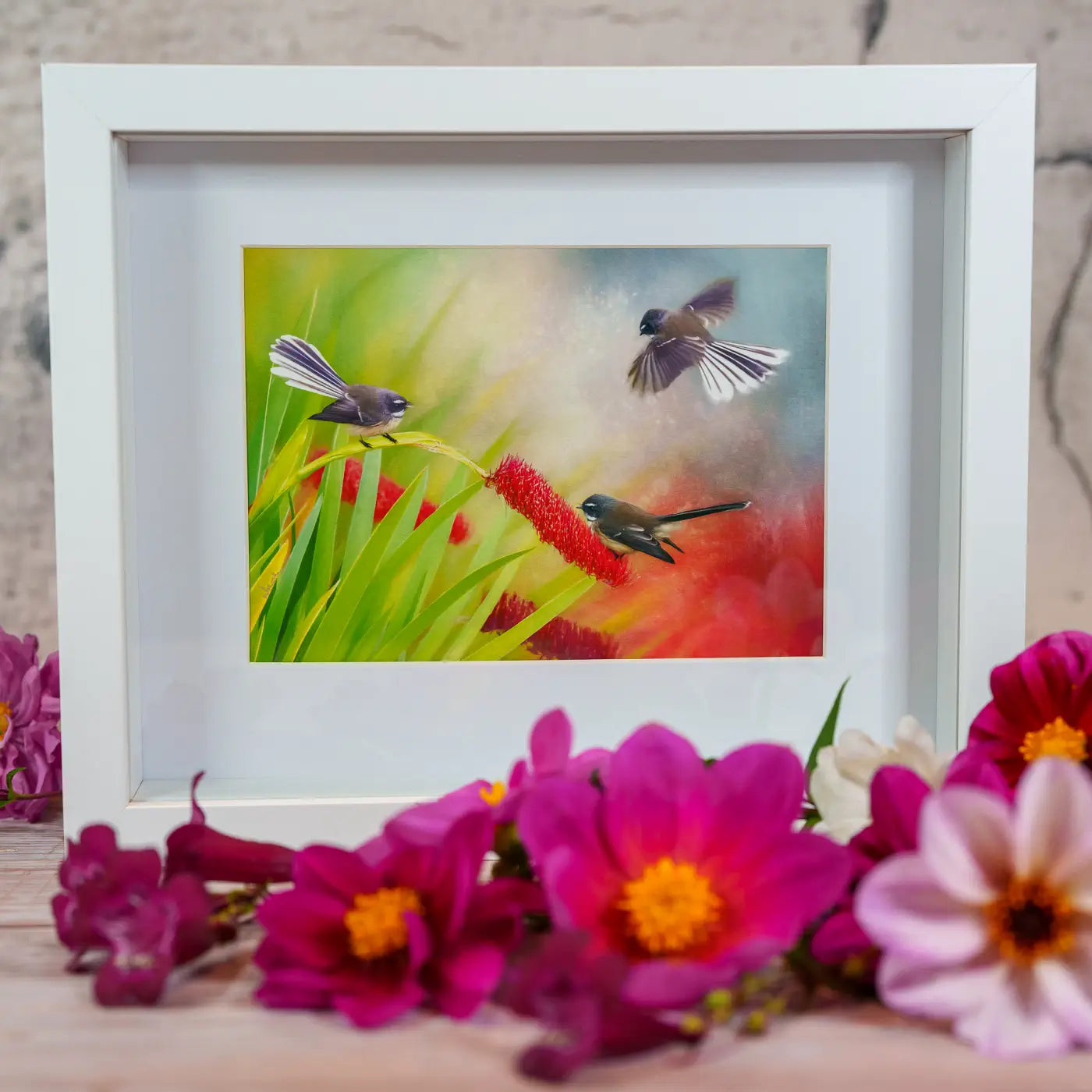 front view of framed art amongst flowers