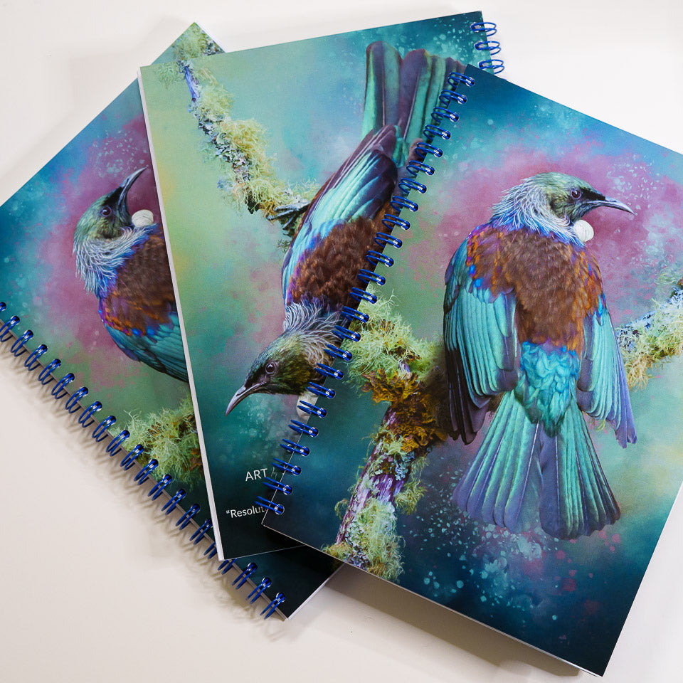 three tui notebooks fanned out showing front and back covers